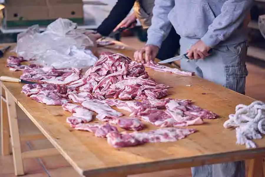 hombre-cortando-carne-en-la-mesa