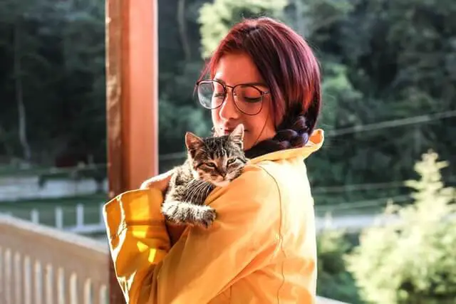 mujer cargando un gato domestico