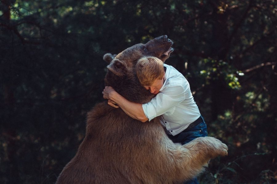 hombre abrazando a un oso